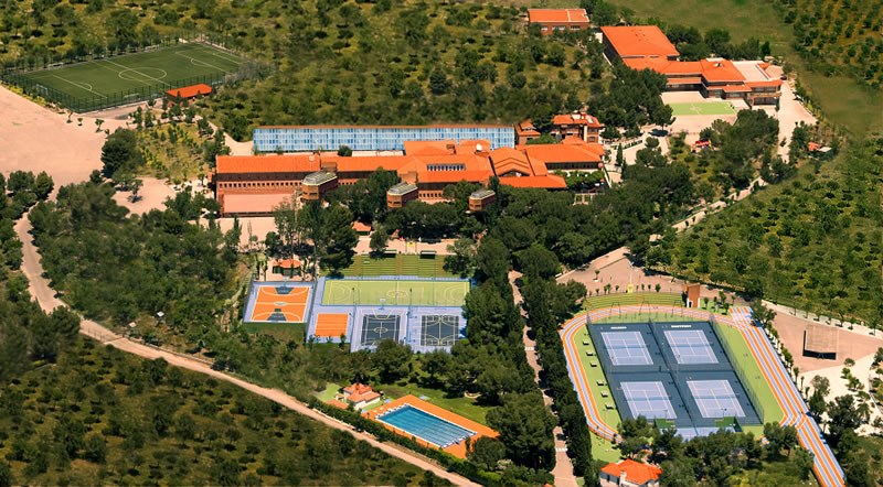 Aerial view of a sports complex featuring various courts and green spaces.